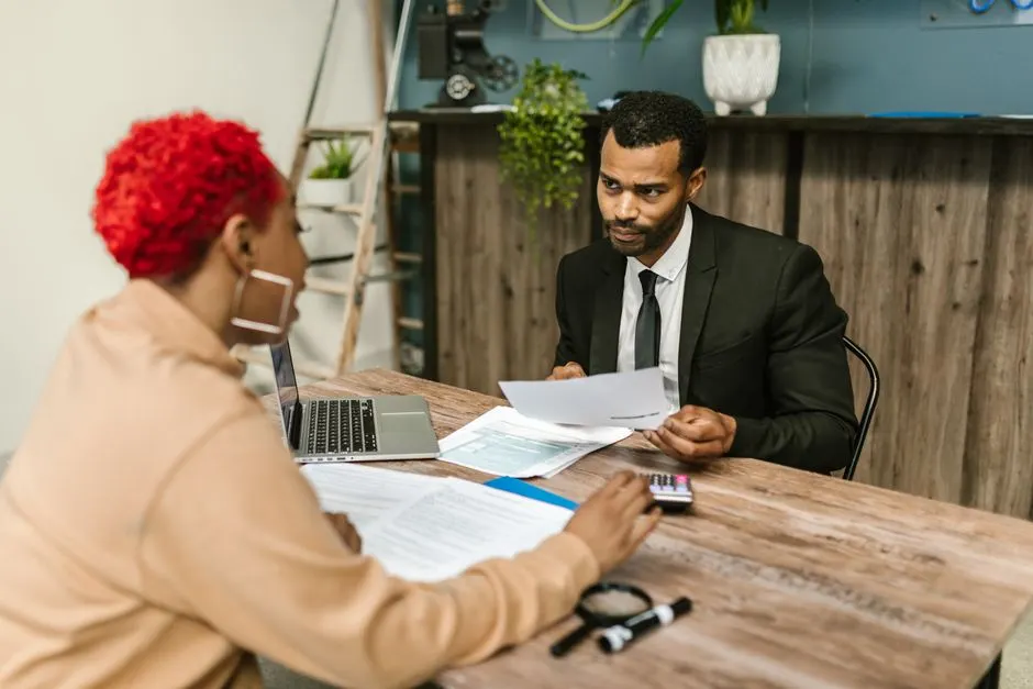 Chef d'entreprise posant des questions à un expert-comptable dans un bureau lumineux